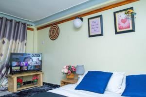 a bedroom with a bed and a tv on a wall at Shan cozy haven in Jinja