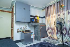 a kitchen with a refrigerator and a stove at Shan cozy haven in Jinja
