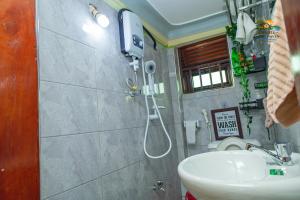a bathroom with a shower and a sink at Shan cozy haven in Jinja +9 photos