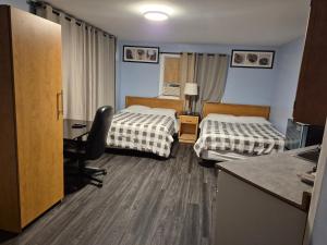 a hotel room with two beds and a desk at Park Side Motel in Peterborough
