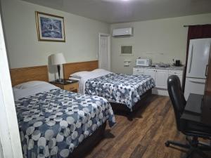 a hotel room with two beds and a kitchen at Park Side Motel in Peterborough
