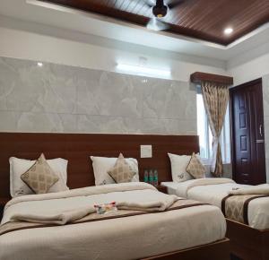 a bedroom with two beds and a wall at Annai Ocean Park in Velankanni