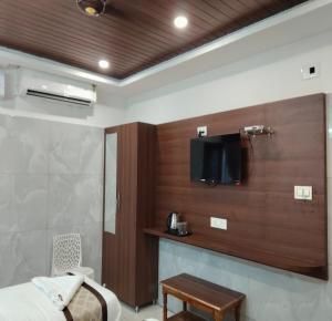 a room with a bed and a tv on a wall at Annai Ocean Park in Velankanni