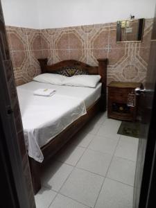 a bedroom with a bed with a white sheets and a table at Hotel La Palma Girardot in Girardot +2 photos