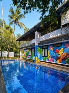 a house with a swimming pool in front of a building with a mural at 1 Forest Soul - Forest Side Retreat with Pool in Batheri