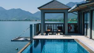 a house with a swimming pool next to the water at Vedana Lagoon Resort & Spa in Hue