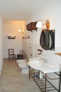 a bathroom with three sinks and two toilets at Le case della giardiniera in Pralormo