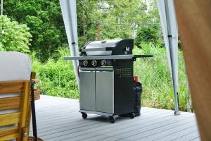 a grill on a screened porch with a bed at Canopy Villa Nuang Hill in Bentong