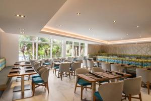 a dining room with tables and chairs and windows at Holiday Inn Miami Beach-Oceanfront by IHG in Miami Beach