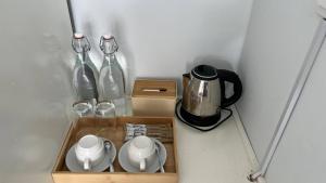a wooden tray with a tea set and two bottles at MN Koh Kong Resort in Koh Kong