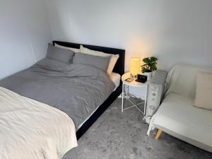 a bedroom with a bed and a chair and a table at Sydney Studio with Private Bathroom & Kitchen in Revesby