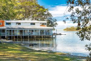 a building on a dock on a body of water at Luminara Luxury Lakefront in Smiths Lake