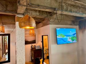 a living room with a flat screen tv on the wall at Drift Inn Kata Beach, Guest House in Kata Beach