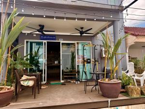 a patio with potted plants and lights at Drift Inn Kata Beach, Guest House in Kata Beach