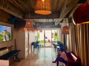 a woman sitting on a couch in a restaurant at Drift Inn Kata Beach, Guest House in Kata Beach +7 photos