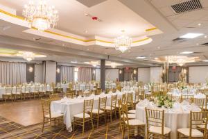 a banquet hall with tables and chairs and chandeliers at Holiday Inn Plainview-Long Island by IHG in Plainview +49 photos