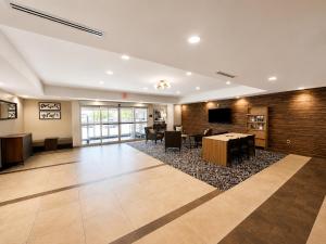 a lobby with a table and chairs and a tv at Candlewood Suites Auburn by IHG in Auburn