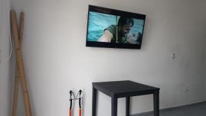 a tv hanging on a wall with a table and a bench at La Pastora in Monterrey