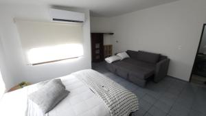 a bedroom with a white bed and a couch at La Pastora in Monterrey