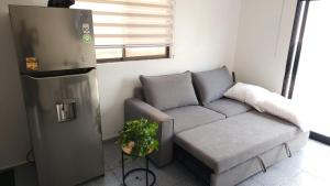 a small living room with a couch and a refrigerator at La Pastora in Monterrey