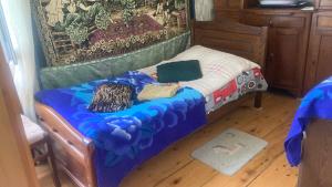a small bedroom with a bed with a blue comforter at noras guesthauze 2026 in Zhabeshi +26 photos