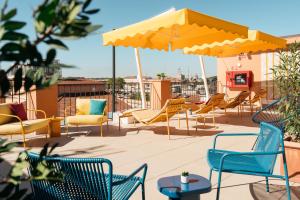 a patio with chairs and umbrellas on a roof at Ruby Lilou Hotel Marseille by IHG in Marseille