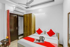 a hotel room with a bed with red pillows at Hotel O Premium Inn in New Delhi