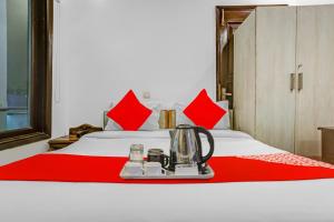a hotel room with a bed with a tea kettle on it at Hotel O Premium Inn in New Delhi +17 photos