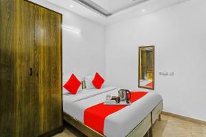 a bedroom with a bed with red pillows at Hotel O Premium Inn in New Delhi