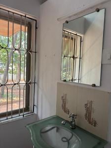 a bathroom with a sink and a mirror and a window at 3bhk villa in Lalbagh in Mangalore +22 photos