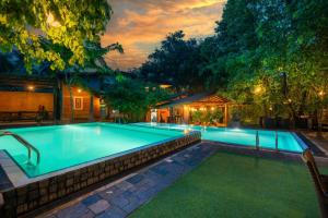 a swimming pool in a backyard at night at Wasala Banquets & Nature Resort in Radawana
