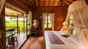 a bedroom with a bed in a room with a balcony at Nan Seasons Boutique Resort in Nan +39 photos