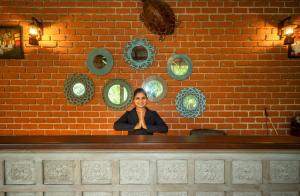 a woman is smiling behind a counter in a brick wall at Wasala Banquets & Nature Resort in Radawana +40 photos