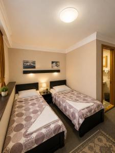 a bedroom with two beds and a bathroom at Daeli Hotel in Mestia