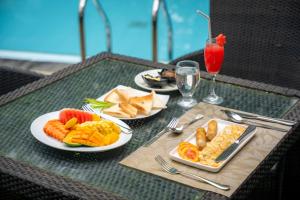 a table with plates of food and a drink at Wasala Banquets & Nature Resort in Radawana