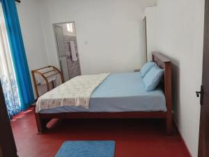 a bedroom with a bed in a room with a mirror at NIVRA Homestay in Kumbalwela