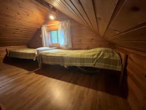 an attic bedroom with two beds in a log cabin at Arola 2 in Syöte