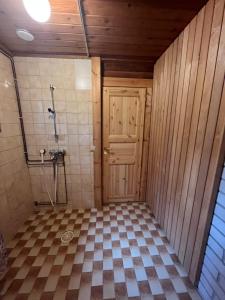 a bathroom with a shower and a wooden door at Arola 2 in Syöte