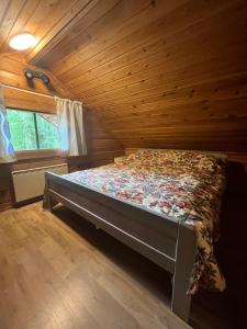 a bedroom with a bed in a wooden cabin at Arola 2 in Syöte