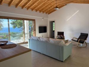 a living room with a blue couch and a tv at Forest and Sea view villas in Samothraki