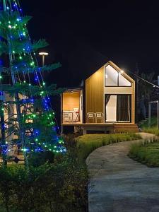 a holiday house with a christmas tree in front of it at บ้านนอร์ดิก เฮาส์ เขาค้อ in Khao Kho
