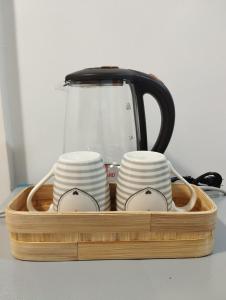 a tray with plates and a tea pot and cups at TDGuestRoom Siargao in Dapa