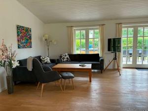 a living room with a couch and a table at Lovely Cottage With Secluded Garden in Rødby
