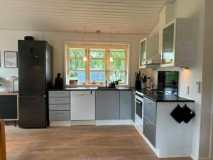 a large kitchen with white appliances and a window at Lovely Cottage With Secluded Garden in Rødby