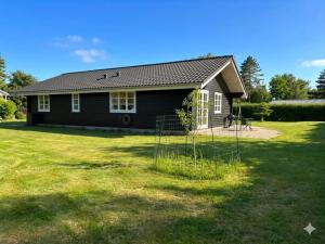 a house with a yard in front of it at Lovely Cottage With Secluded Garden in Rødby