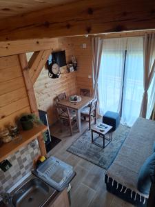 a kitchen and living room of a log cabin at Vikendica Neven 3 in Popovići