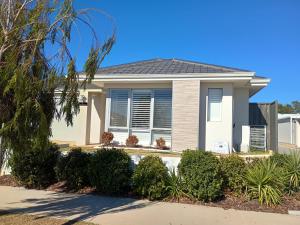 a house with a palm tree in front of it at Eden beach retreat in Jindalee