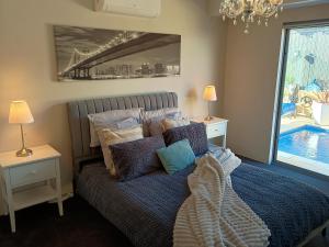 a bedroom with a bed with pillows on it at Eden beach retreat in Jindalee +19 photos