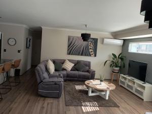 a living room with a couch and a table at Eden beach retreat in Jindalee