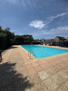 a large swimming pool with blue water at Mamounette in Sarzeau